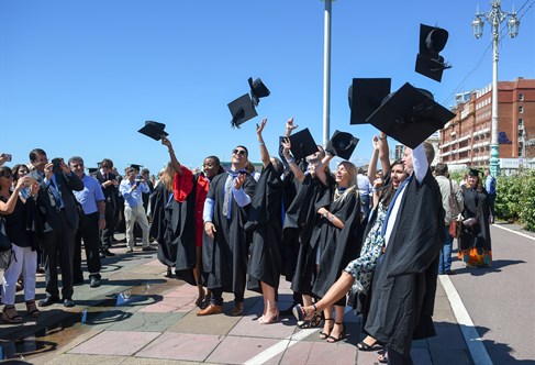 A group of graduates throwing their caps in the air